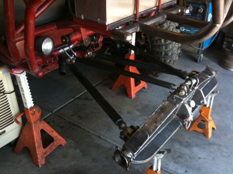 Suzuki Samurai - The rear axle assembly of a custom off-road vehicle is supported by jack stands in a garage.