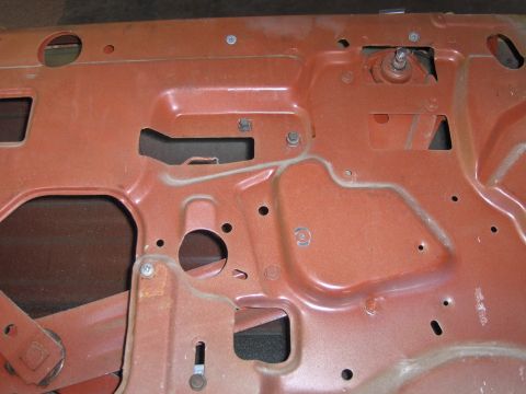 1970 Chevrolet Camaro - Interior view of an orange car door, revealing the internal structure and window regulator mechanism.