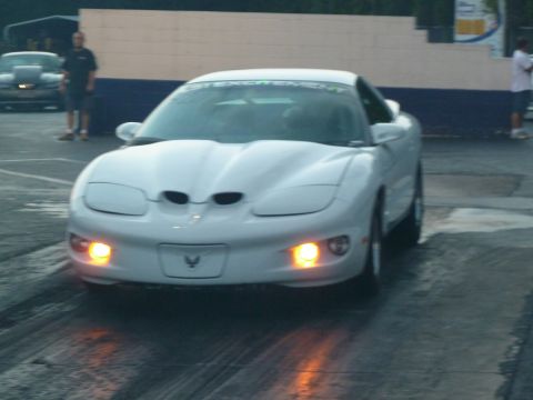 1992 Ford Mustang - A white Pontiac Firebird Trans Am is lined up on a drag strip, with a banner on its windshield.