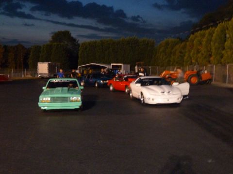 1992 Ford Mustang - Multiple vehicles gathered at a drag strip during twilight, with tractors visible in the background.