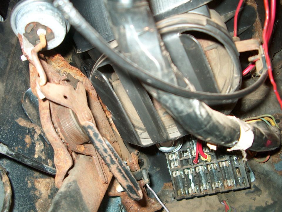 Rusty pedals and fuse box with red and yellow wires