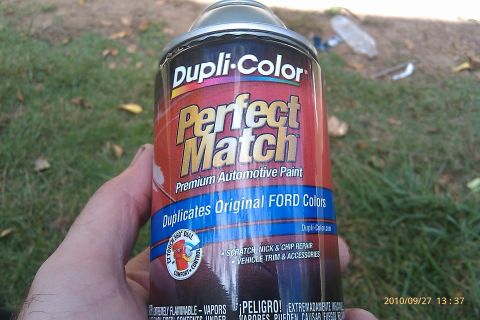 2000 Mercury Grand Marquis - A can of Dupli-Color Perfect Match automotive paint is held, designed to duplicate original Ford colors for scratch, nick, and chip repair.