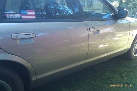 2000 Mercury Grand Marquis - Side view of a sedan, showing the doors and rear wheel well. Features a Flowmaster sticker.
