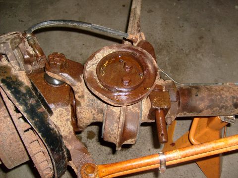 1994 Ford Bronco - Close-up of a heavily rusted front axle assembly, likely from an older vehicle.