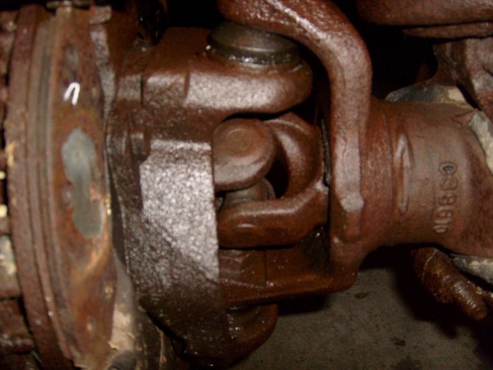 close-up of a rusty driveshaft u-joint with part number C38610 visible