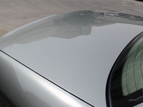 2001 Mercury Grand Marquis - The image shows the roof and hood of a silver car, with reflections of the surroundings.