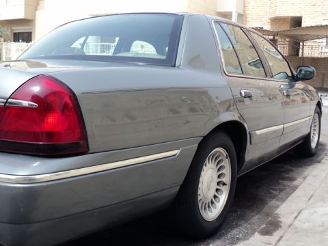 2001 Mercury Grand Marquis - Rear passenger side view of a gray Mercury Grand Marquis sedan parked on a street.