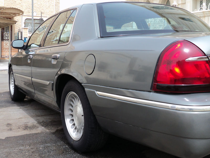 Gray 2001 Mercury Grand Marquis sedan, rear quarter panel and taillight visible, parked on asphalt