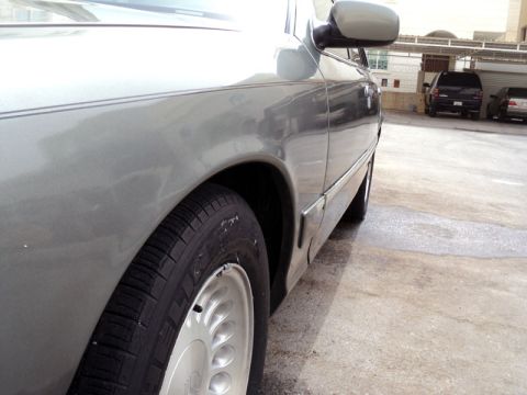 2001 Mercury Grand Marquis - 2001 Mercury Grand Marquis side profile, showing the front wheel and fender area.