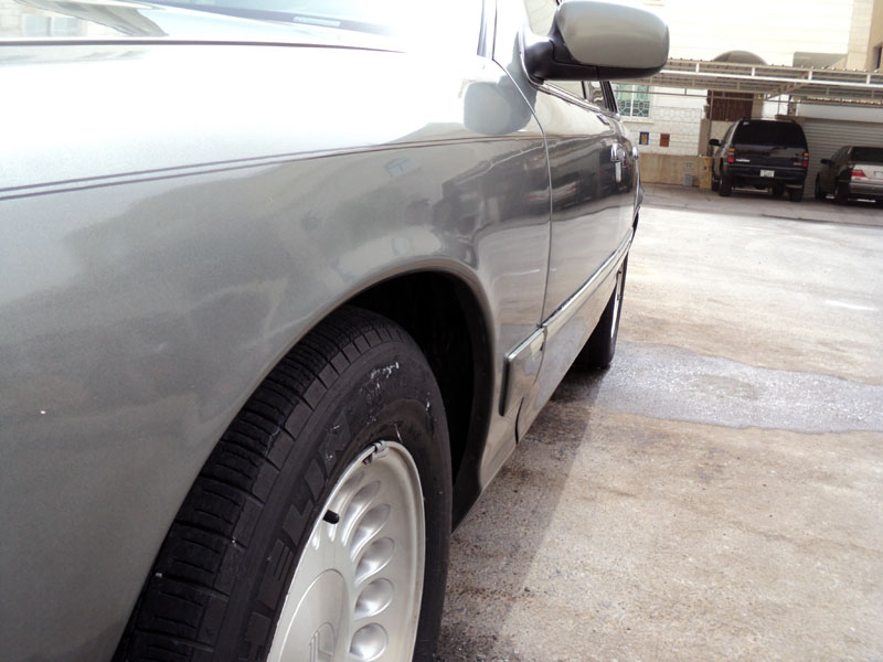 Side view of a 2001 Mercury Grand Marquis showing the front fender, wheel, and door