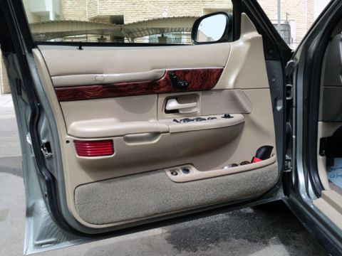 2001 Mercury Grand Marquis - The interior door panel of a 2001 Mercury Grand Marquis features wood grain accents and power window controls.