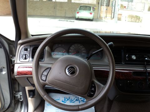 2001 Mercury Grand Marquis - The interior of a 2001 Mercury Grand Marquis, with a glimpse of another vehicle outside through the windshield.