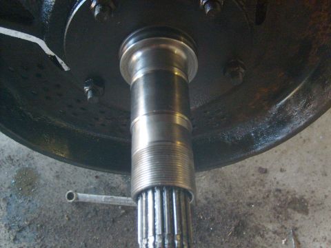 1994 Ford Bronco - Close-up view of a wheel hub and axle splines, with a wrench visible on the concrete floor.