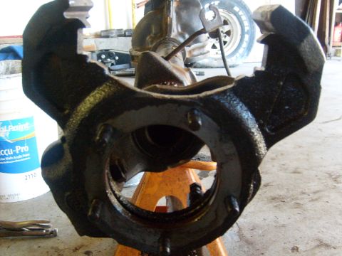1994 Ford Bronco - A close-up view of a vehicle's suspension component, possibly a knuckle or spindle, undergoing maintenance.