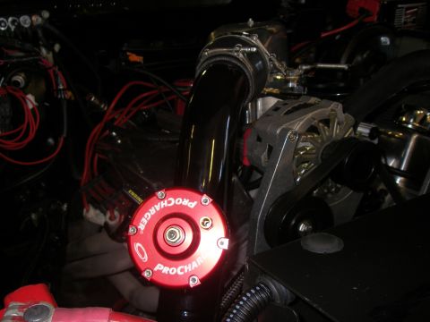 1990 Ford Bronco - Close-up of engine bay components, including a ProCharger cap and alternator.