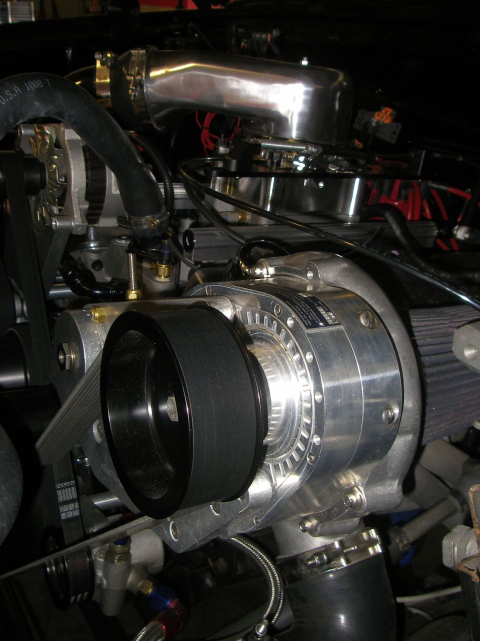 Engine supercharger with polished intake pipe and black belt
