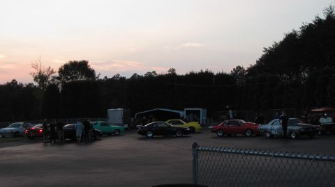 1992 Ford Mustang - Cars gathered at a drag strip, with a sunset sky and trees lining the perimeter.
