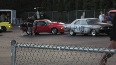 1992 Ford Mustang - Two cars, a red 1992 Ford Mustang and a silver car, are positioned side-by-side at a drag racing event.