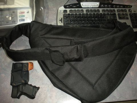 1996 Ford Bronco - A black bag and a handgun holster are laid out on a surface next to a computer keyboard and other electronic devices.