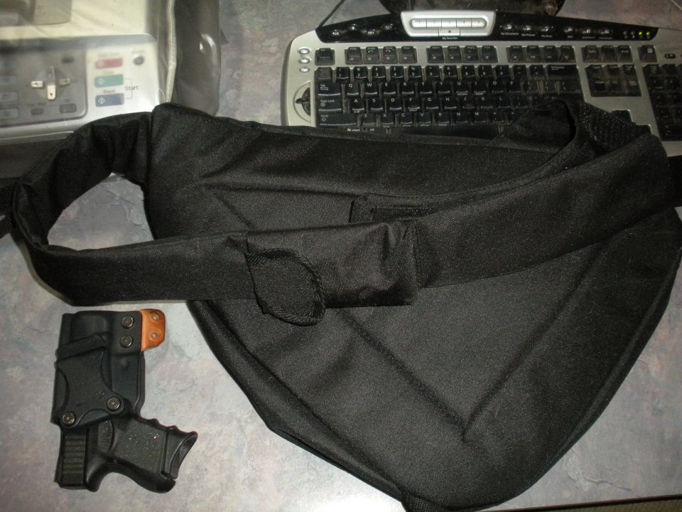black bag with strap, handgun in holster, keyboard, and some electronic device