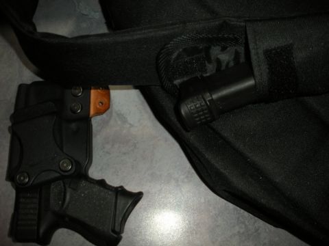 1996 Ford Bronco - A black handgun is secured in a black holster attached to a black strap.