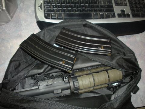 1996 Ford Bronco - Rifle and magazines are placed inside a black bag next to a keyboard.