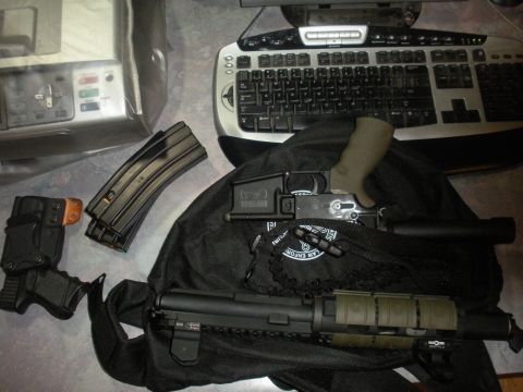 1996 Ford Bronco - Firearms and accessories are laid out on a black bag next to a computer keyboard and a scanner.