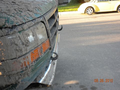 1989 Ford Bronco - Mud-covered Ford Bronco parked on a street next to a yellow car.
