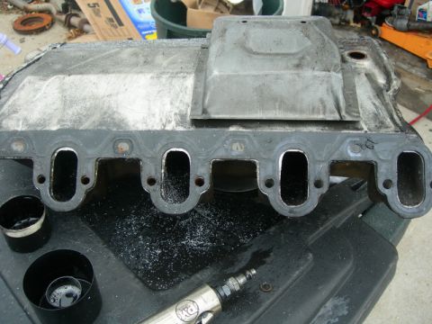 1984 Ford Bronco - Intake manifold gasket being worked on with a die grinder and associated tools.