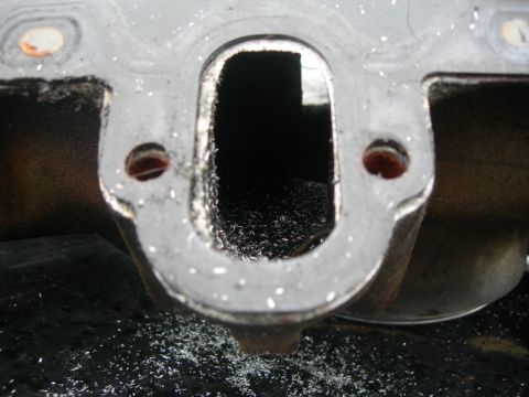 1984 Ford Bronco - Close-up of an engine intake manifold port, showing metal shavings from machining.