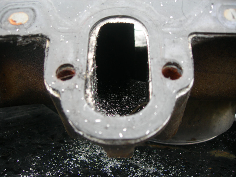 Engine intake manifold port with metal shavings inside and around it