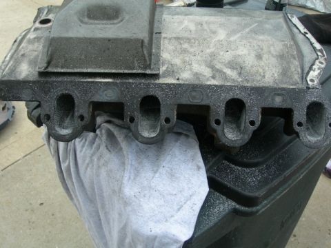 1984 Ford Bronco - Close-up of an intake manifold, likely for a Ford vehicle, with the Supermotors.net logo visible in the lower right corner.