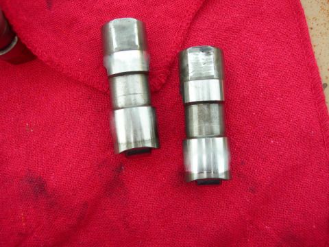 1984 Ford Bronco - Two metal engine lifters are shown resting on a red cloth, likely part of a diesel engine rebuild.