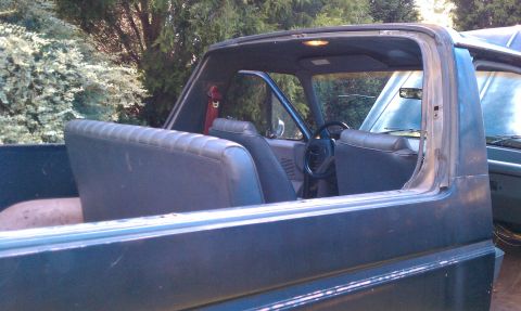 1987 Ford Bronco - Interior view of a 1987 Ford Bronco, with a second vehicle visible in the background.