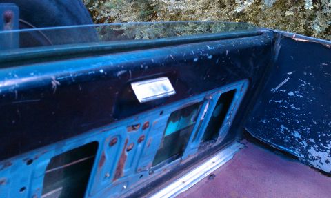 1987 Ford Bronco - Close-up view of a vehicle's interior door panel, showing the window frame and internal mechanisms.