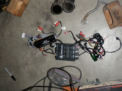 1994 Ford Bronco - Various car audio electronic components and wiring are spread out on a concrete surface.