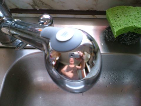 1989 Ford Bronco - A person takes a selfie in the reflection of a chrome sink faucet.