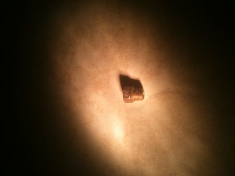 1989 Ford Bronco - A single metal bolt is illuminated against a textured background.