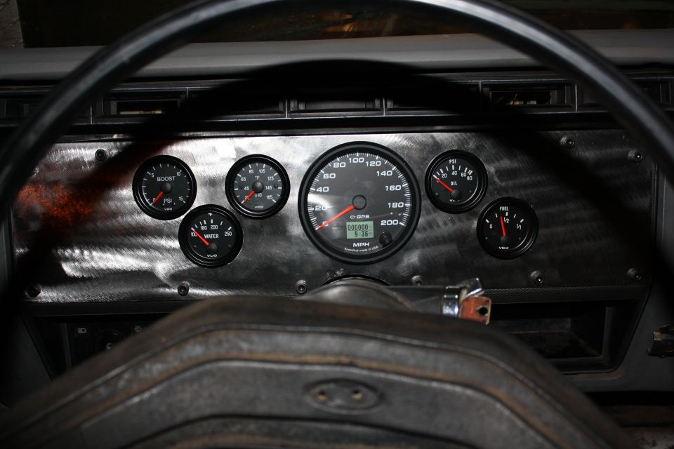 Dashboard with multiple gauges including speed, boost, water temp, and fuel. Steering wheel visible