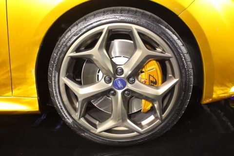 1993 Ford Taurus - Close-up of a yellow car's wheel, a silver rim and a bright yellow brake caliper with the Ford logo.