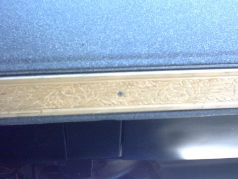 1976 Chevrolet C/K Pickup - Detail of an interior trim piece with carved floral patterns, set against a blue textured background.