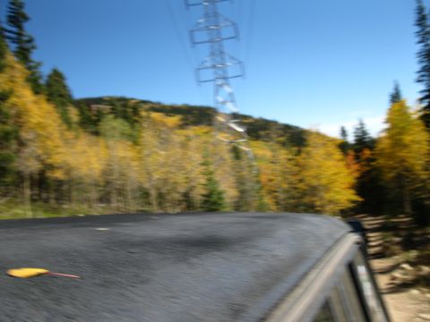 1978 Ford Bronco - Driving through a scenic landscape with autumn foliage and a large power line tower.