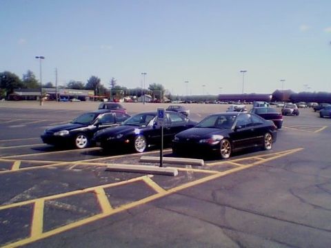1999 Ford Taurus - A sunny day in a parking lot with multiple vehicles parked.