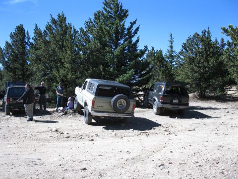 1978 Ford Bronco - Multiple vehicles are parked in an outdoor lot under a clear sky.