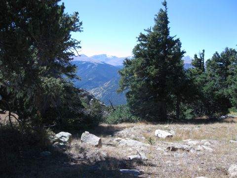 1978 Ford Bronco - A scenic mountain vista unfolds, framed by evergreen trees and scattered rocks on a sunny day.