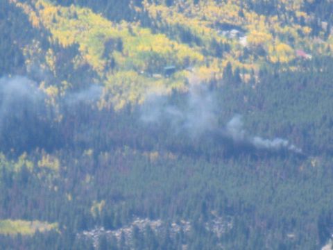 1978 Ford Bronco - A plume of smoke drifts across a wooded hillside, indicating a fire in the distance.