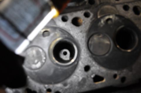 1984 Ford Bronco - Close-up of an engine cylinder head, showing valve openings and a light source.