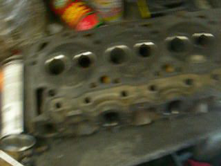 1984 Ford Bronco - A close-up view of an engine cylinder head, with a SuperMotors logo in the corner.