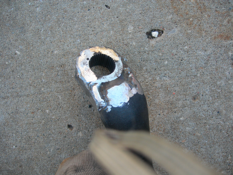 Close-up of a metal part with splines, showing recent welding repairs