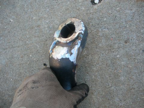1984 Ford Bronco - A gloved hand holds a metal component that has undergone welding repairs.